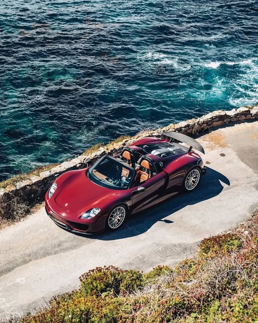 Roter Porsche 918 Spyder an einer Küstenstraße