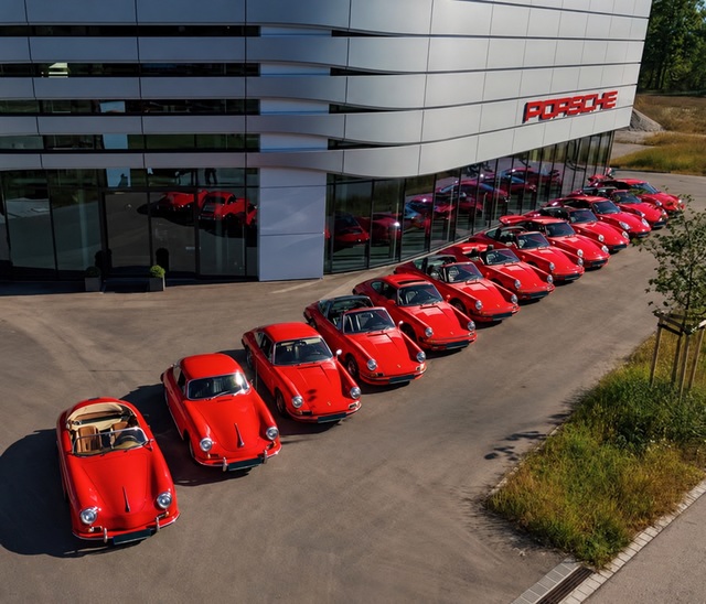 Aufgereihte rote Porsche vor einem Porsche-Zentrum