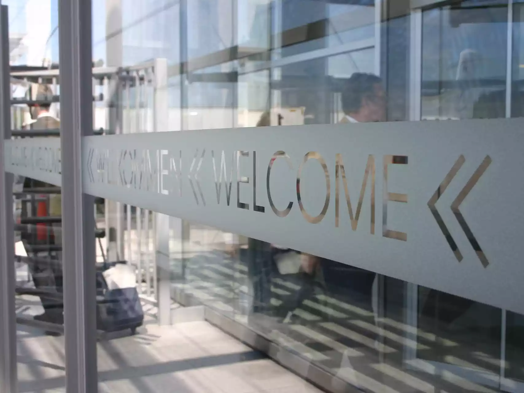 Glasdekor mit WELCOME-Schriftzug an einer Eingangssituation
