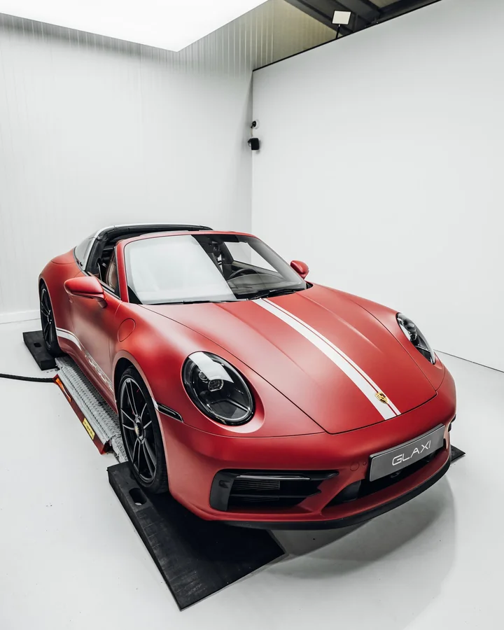 Roter Porsche 911 Targa mit weißen Designstreifen in der GLAXI-Halle