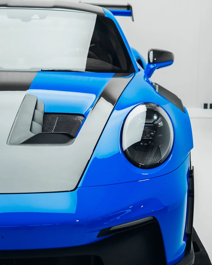 Frontdetail eines blauen Porsche 911 GT3 RS mit sichtbaren Carbon-Elementen