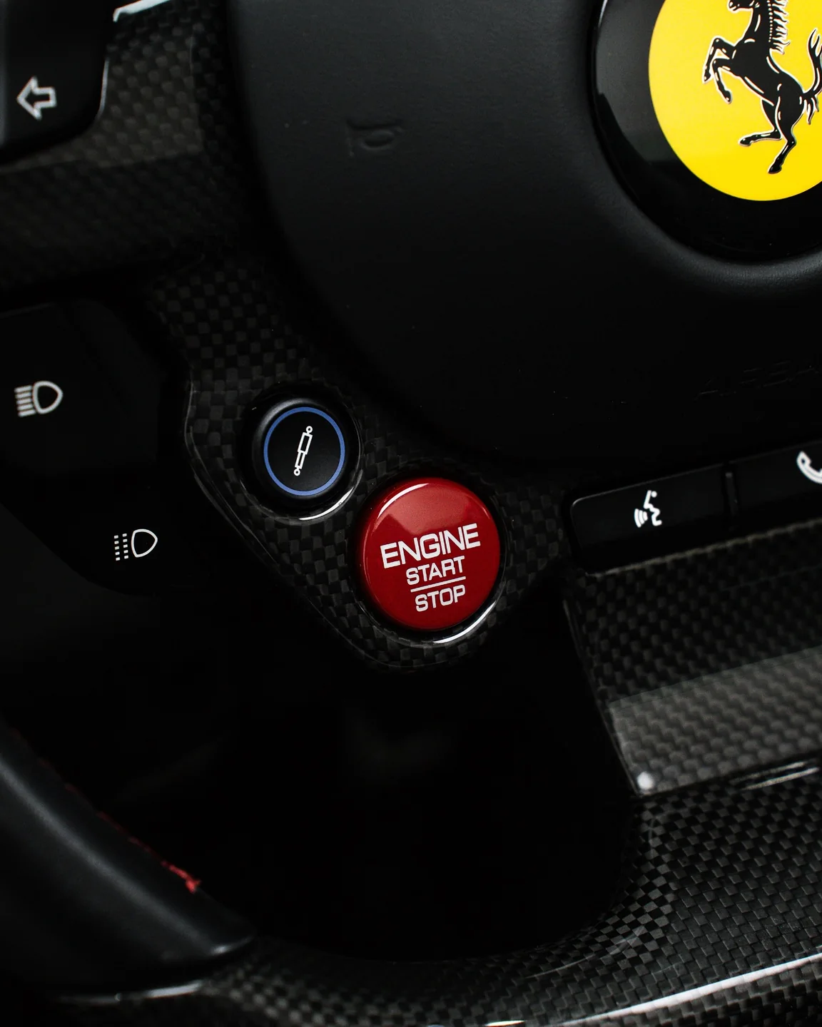Nahaufnahme des Ferrari-Lenkrads mit rotem Engine-Start-Stop-Knopf