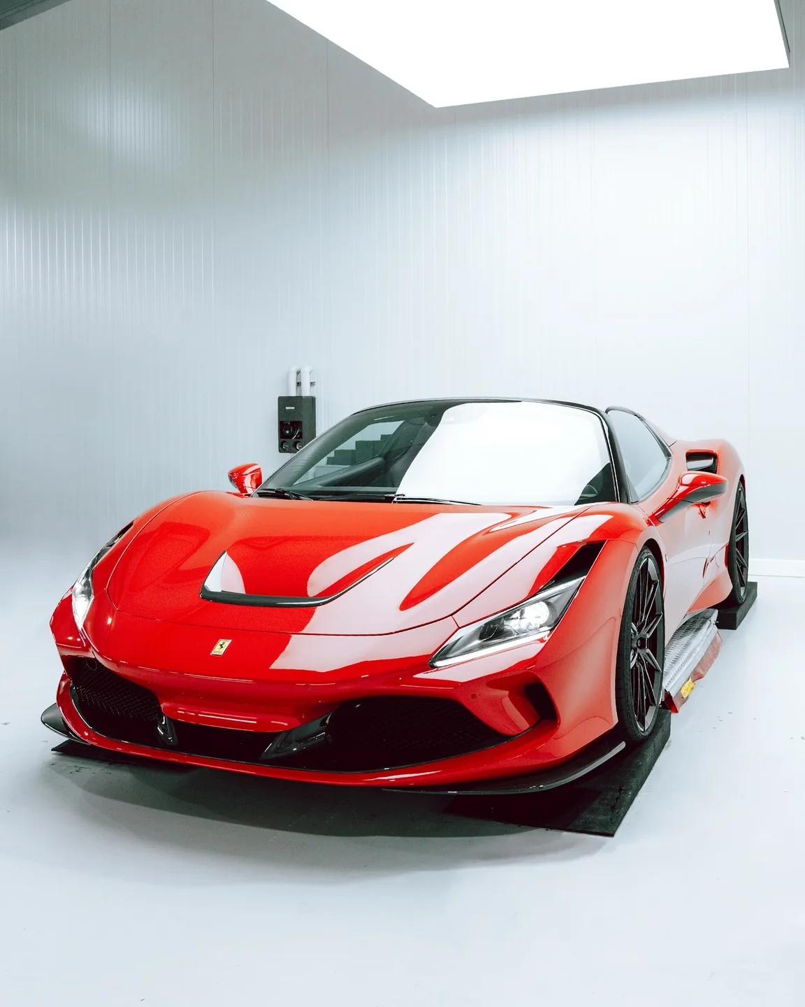 Roter Ferrari F8 Spider schräg von vorn in der weißen GLAXI-Halle