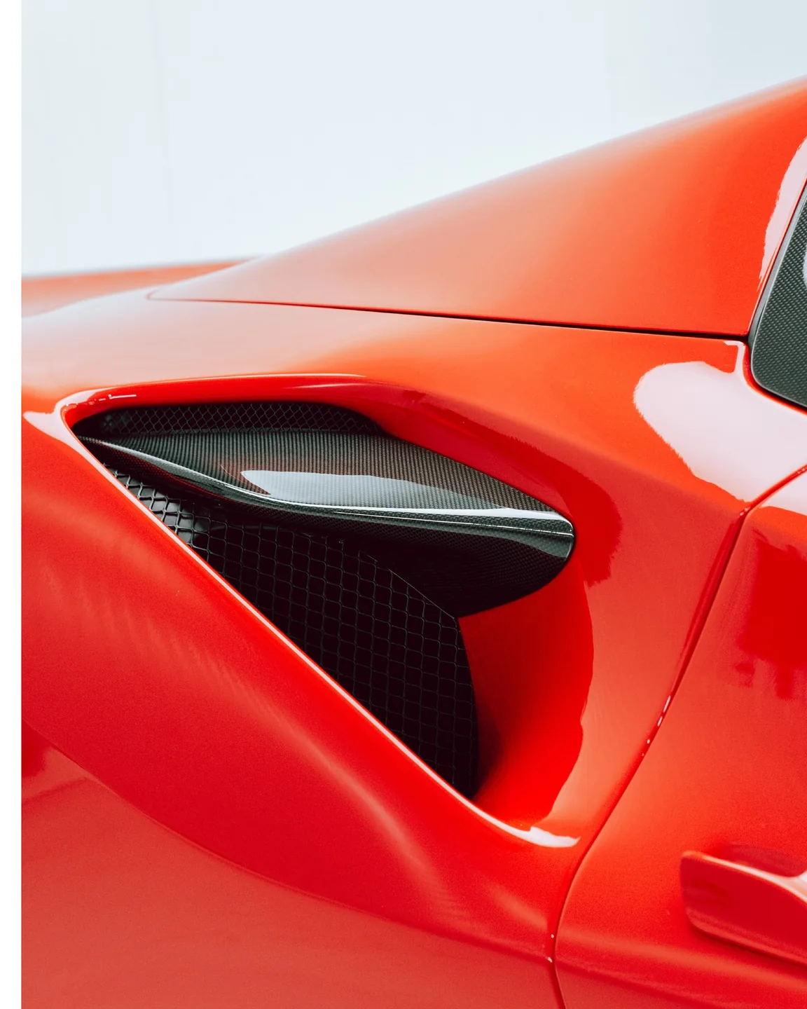 Nahaufnahme des seitlichen Lufteinlasses und der roten Karosseriekante am Ferrari F8 Spider