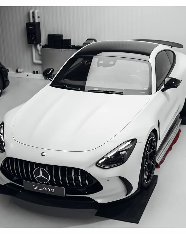 Weißer Mercedes-AMG GT 63 S aus erhöhter Front-Dreiviertelperspektive auf der Hebebühne bei GLAXI
