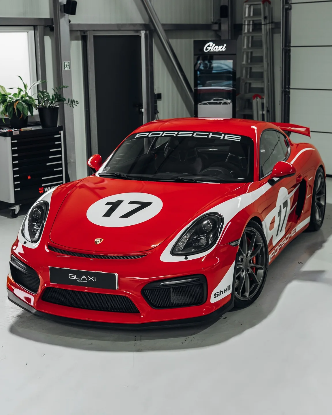 Roter Porsche Cayman GT4 mit weißen Dekorelementen und Startnummer 17 schräg von vorn