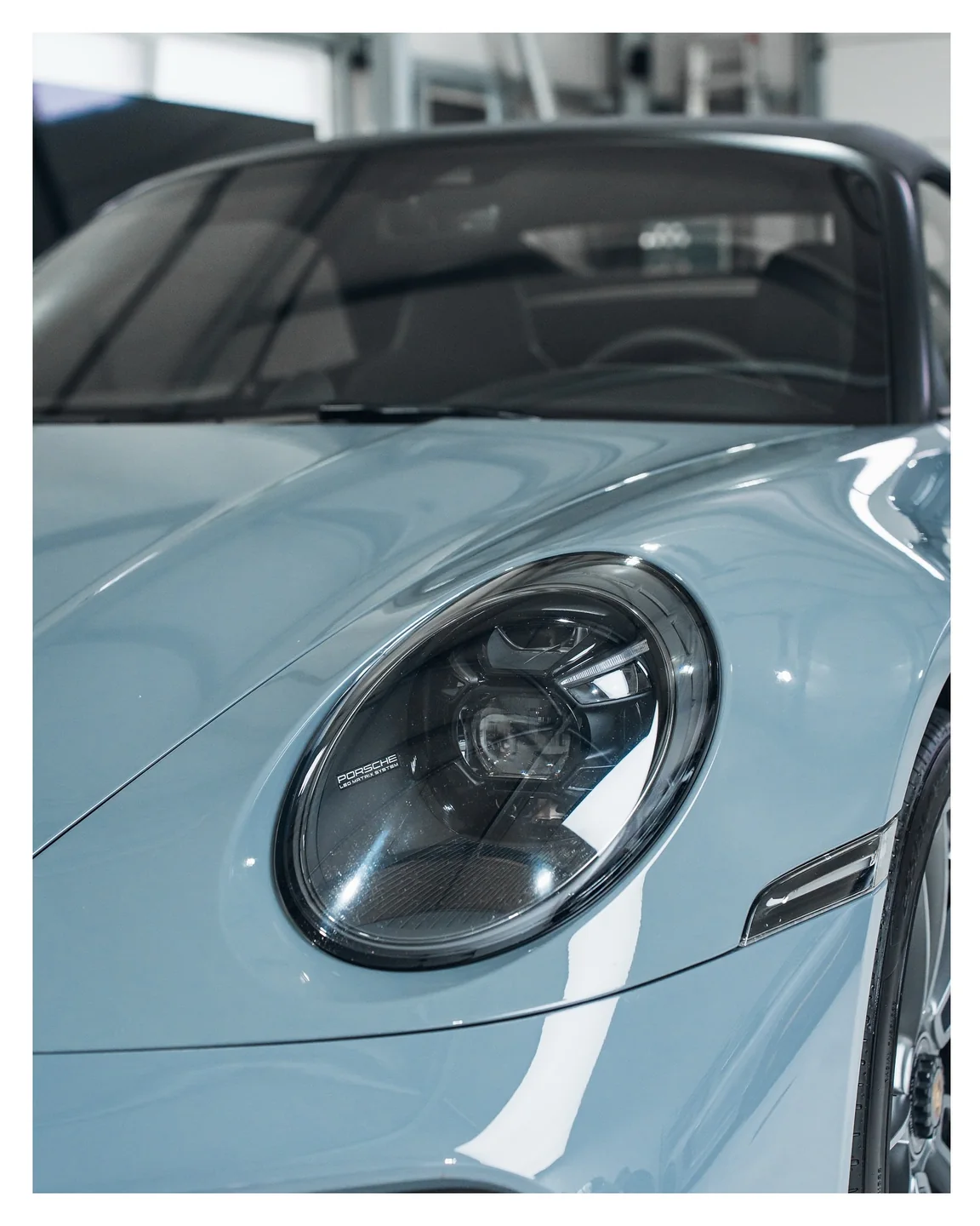 Runder Scheinwerfer und hellblauer Kotflügel des Porsche 911 Turbo S Cabriolet