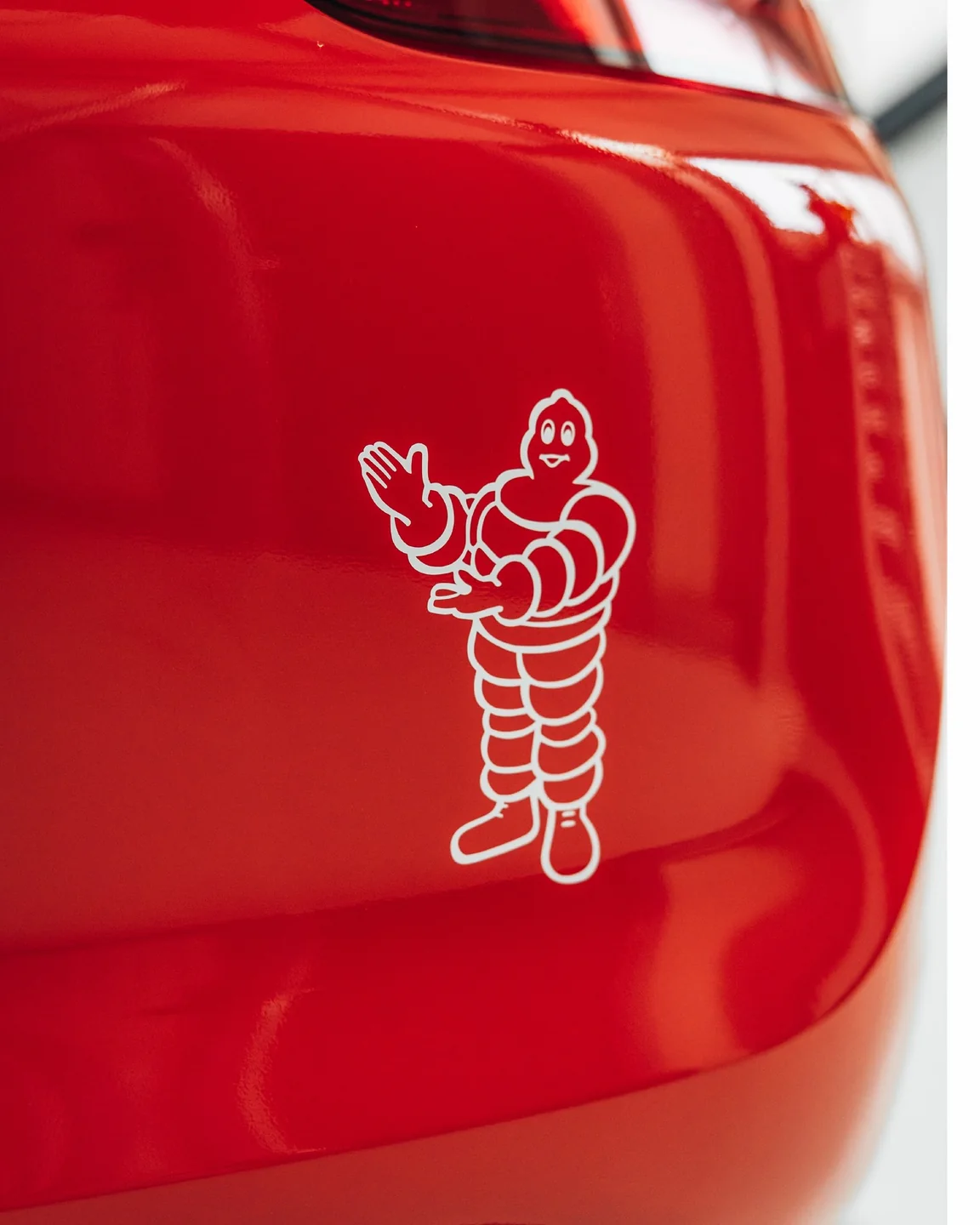 Weißes Michelin-Männchen auf der roten Heckstoßstange des Porsche Cayman GT4
