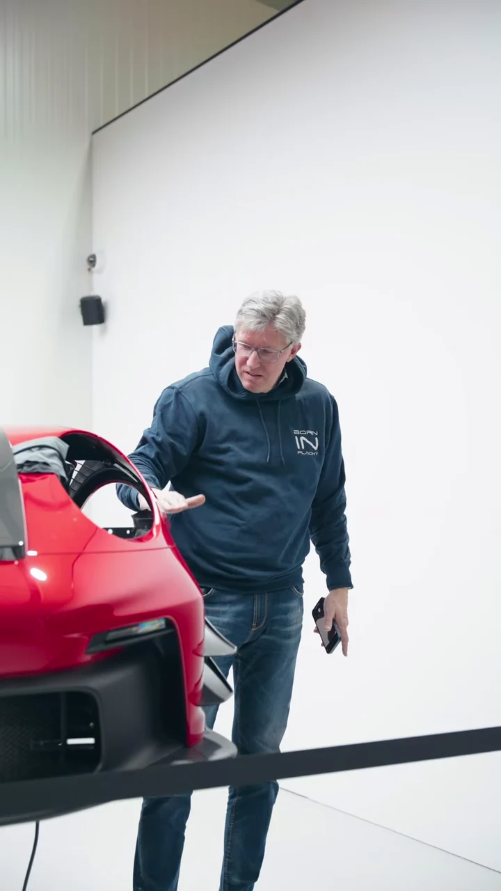 Besucher neben einem roten Porsche in der GLAXI-Werkstatt beim Born-in-Flacht-Treffen am 17. April 2025