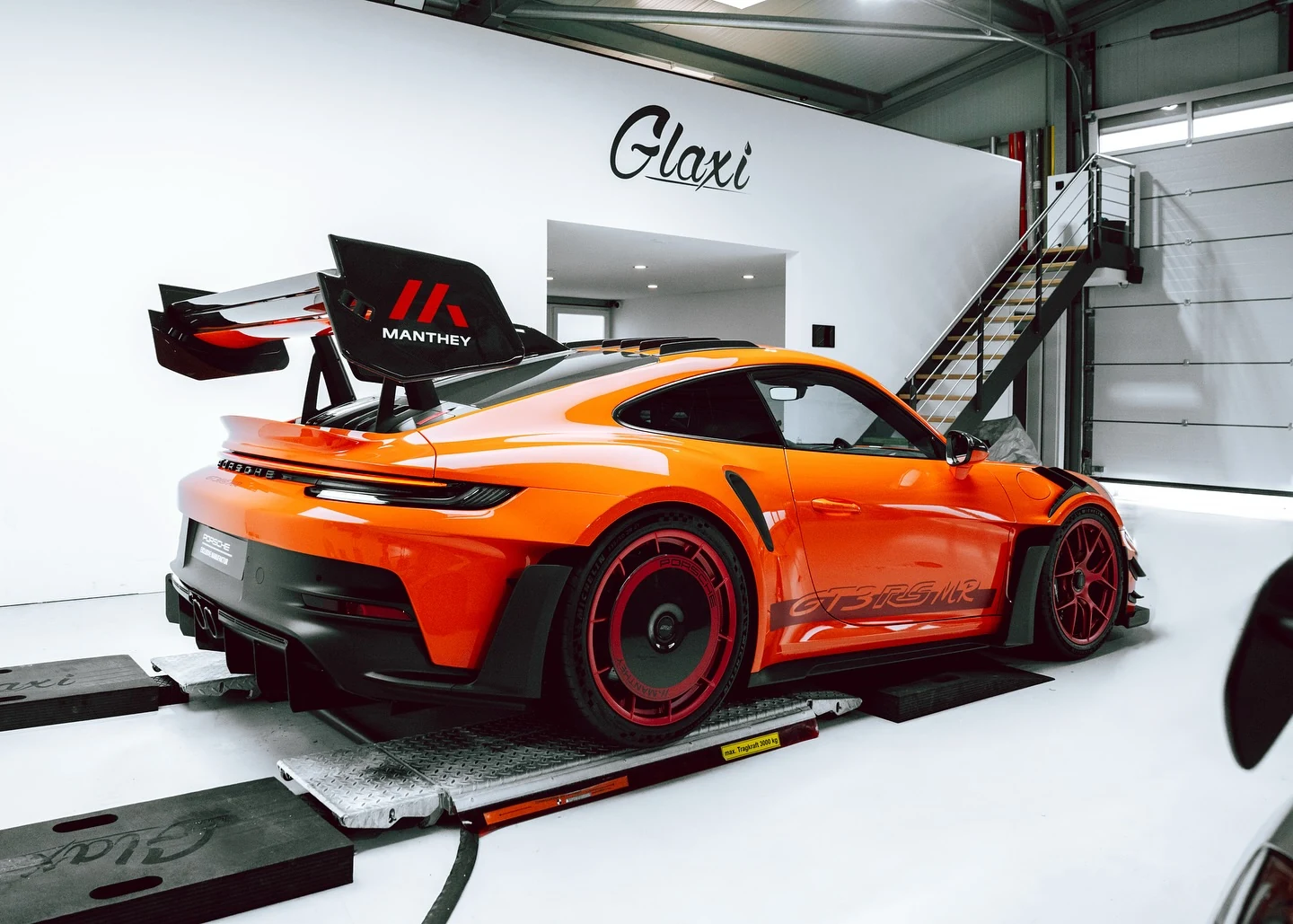 Orangefarbener Porsche 992 GT3 RS Manthey mit markantem Heckflügel nach Fullbody-Lackschutzfolierung bei GLAXI