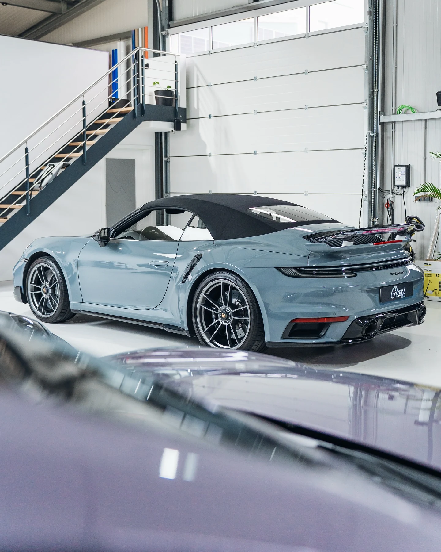 Porsche 911 Turbo S mit individueller Karomuster-Designfolierung, von hinten in der GLAXI-Werkstatt