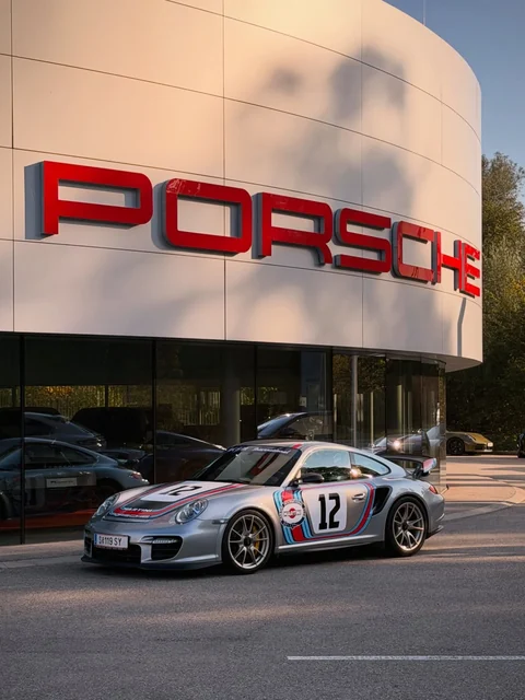 Porsche 997 GT2 RS im Martini-Design vor einem Porsche-Zentrum