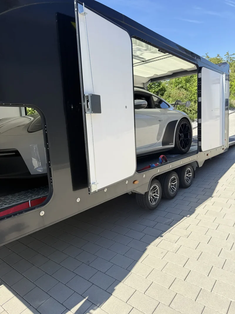 Porsche durch den großen seitlichen Zugang des Anhängers