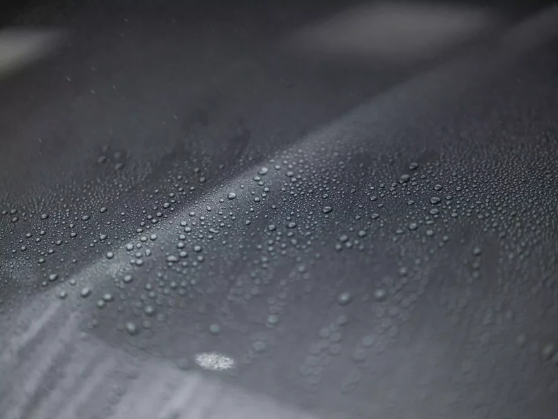 Wassertropfen auf einer Fahrzeugoberfläche als illustrative Oberflächenstudie