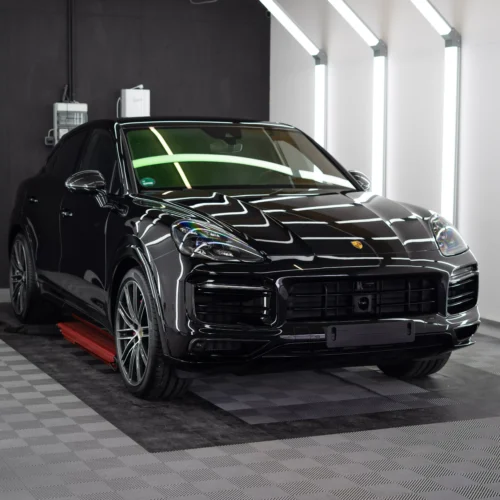 Porsche Cayenne GTS in schwarz metallic in einem Lichttunnel nach der Lackschutzfolierung bei GLAXI in Schwäbisch Hall.