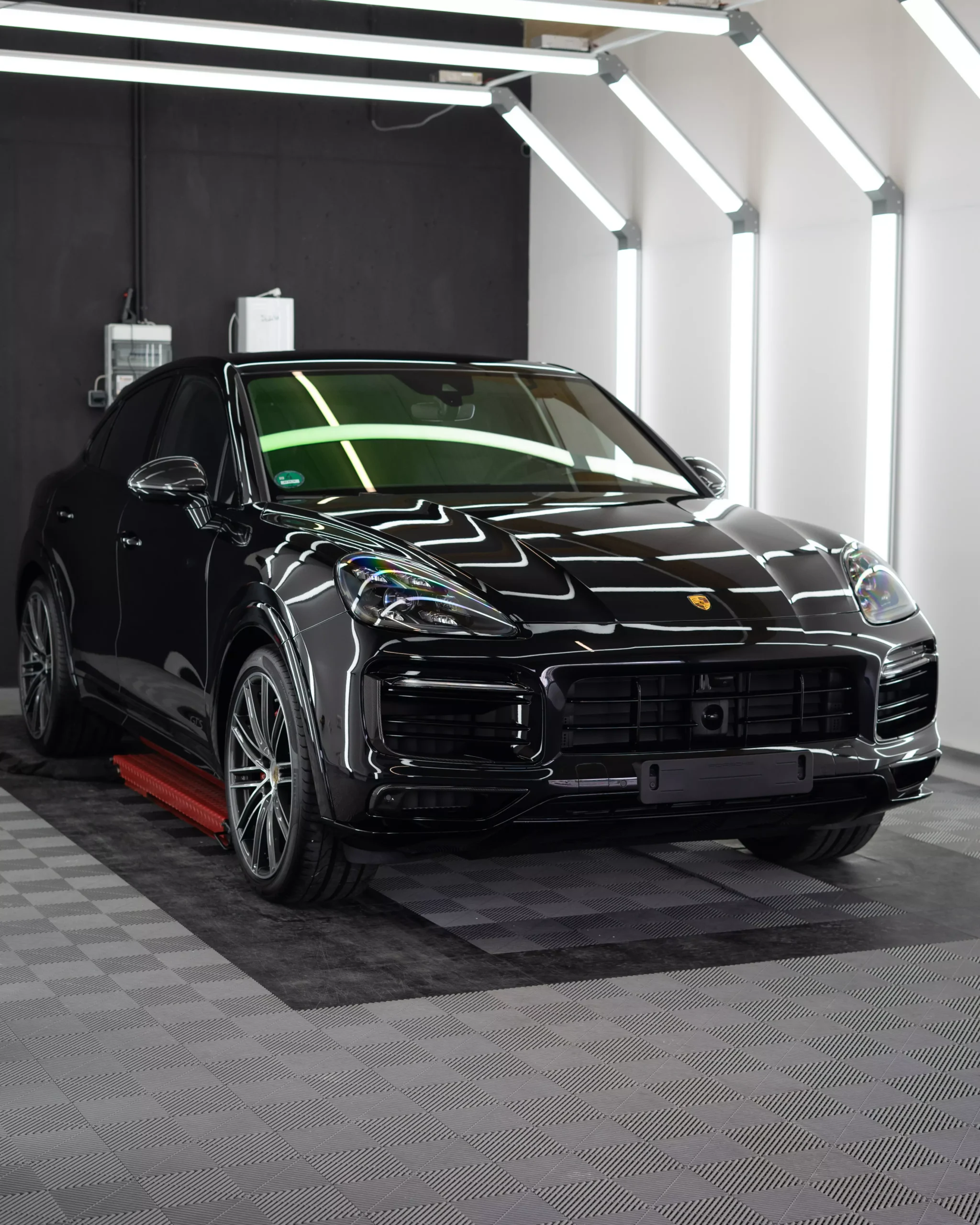 Porsche Cayenne GTS in schwarz metallic in einem Lichttunnel nach der Lackschutzfolierung bei GLAXI in Schwäbisch Hall.