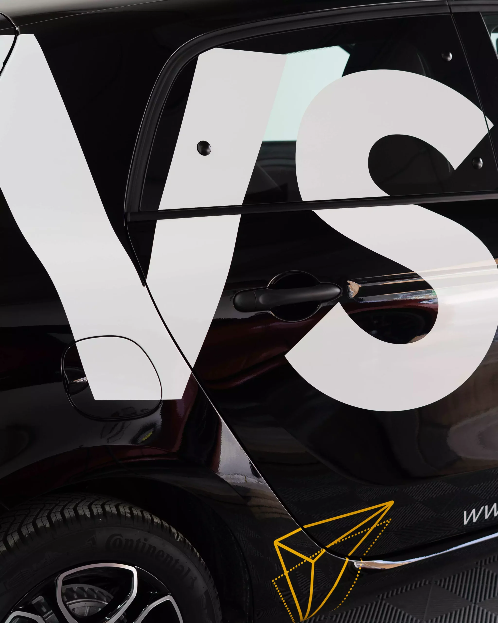 Mehrere Firmenlogos auf einem Auto, Folie auf den Lack geklebt, darunter ein Glaxi Logo. Der Lack glänzt. Fahrzeugbeschriftung