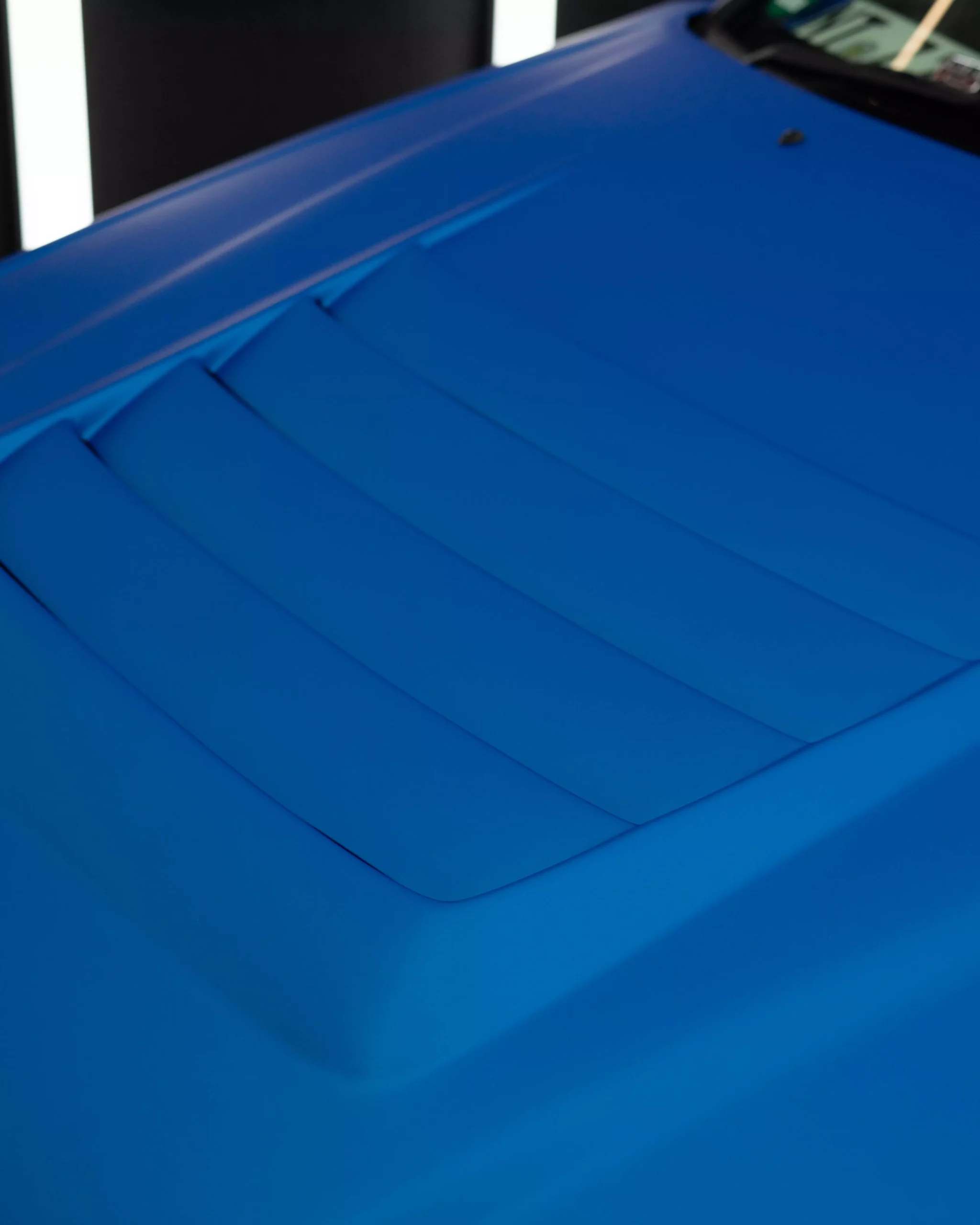 Motorhaube eines blau folierten Nissan Skyline in einem Lichttunnel bei der Firma GLAXI in Schwäbisch Hall