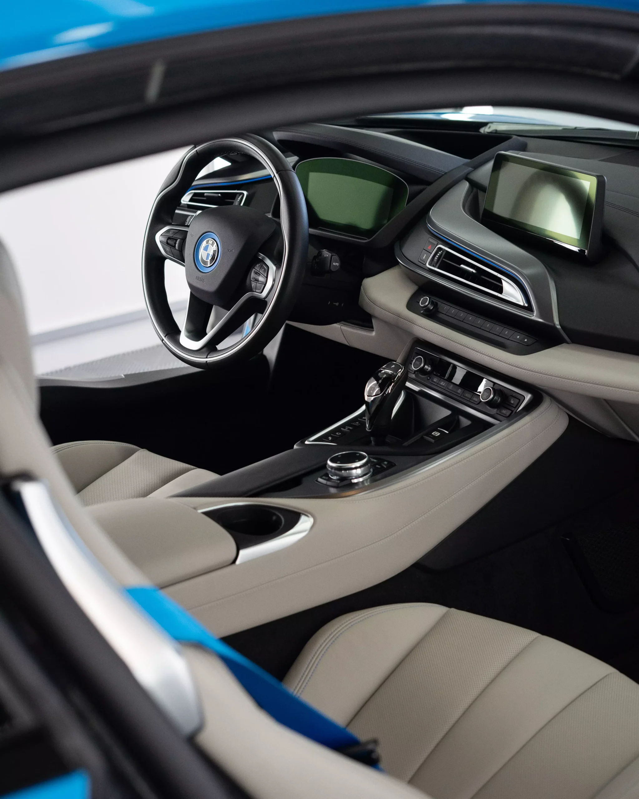 Das Bild zeigt einen BMW i8 nach einer Innenraumreinigung im Rahmen einer Fahrzeugaufbereitung bei Glaxi Autopflege SHA. Nach der Aufbereitung bekommt der blaue BMW mit beidem Leder und schwarzem Lenkrad eine Keramikversiegelung.