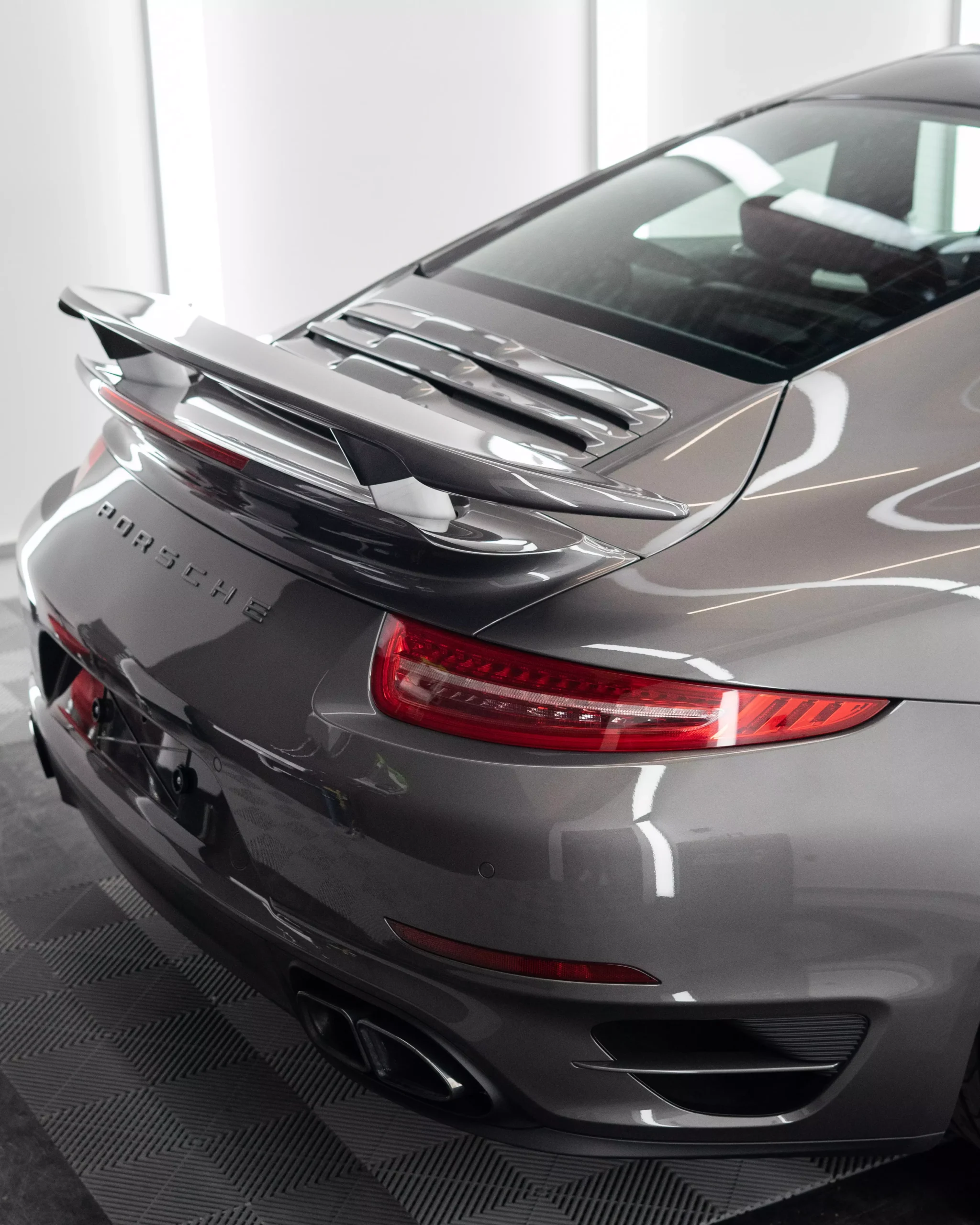Porsche 911 Turbo S Heckansicht in Anthrazit mit einer Lackschutzfolie auf der Front