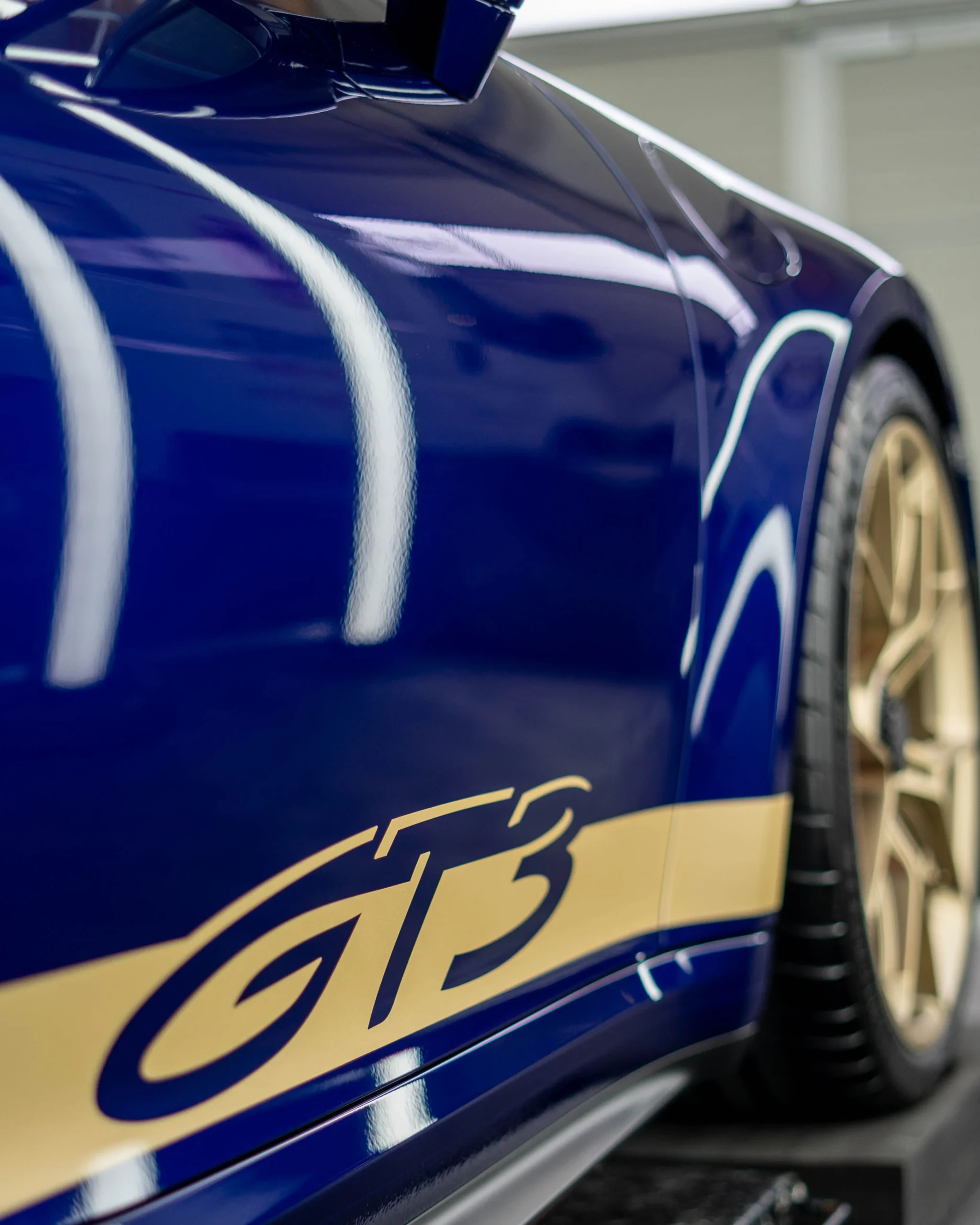 Ein enzianblauer Porsche 992 GT3 mit passenden Felgen und Designelementen in der Farbe Neodym.