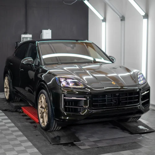 Ein frisch ausgelieferter Porsche Cayenne E-Hybrid in Dunkelolivmetallic des Modelljahres 2024.