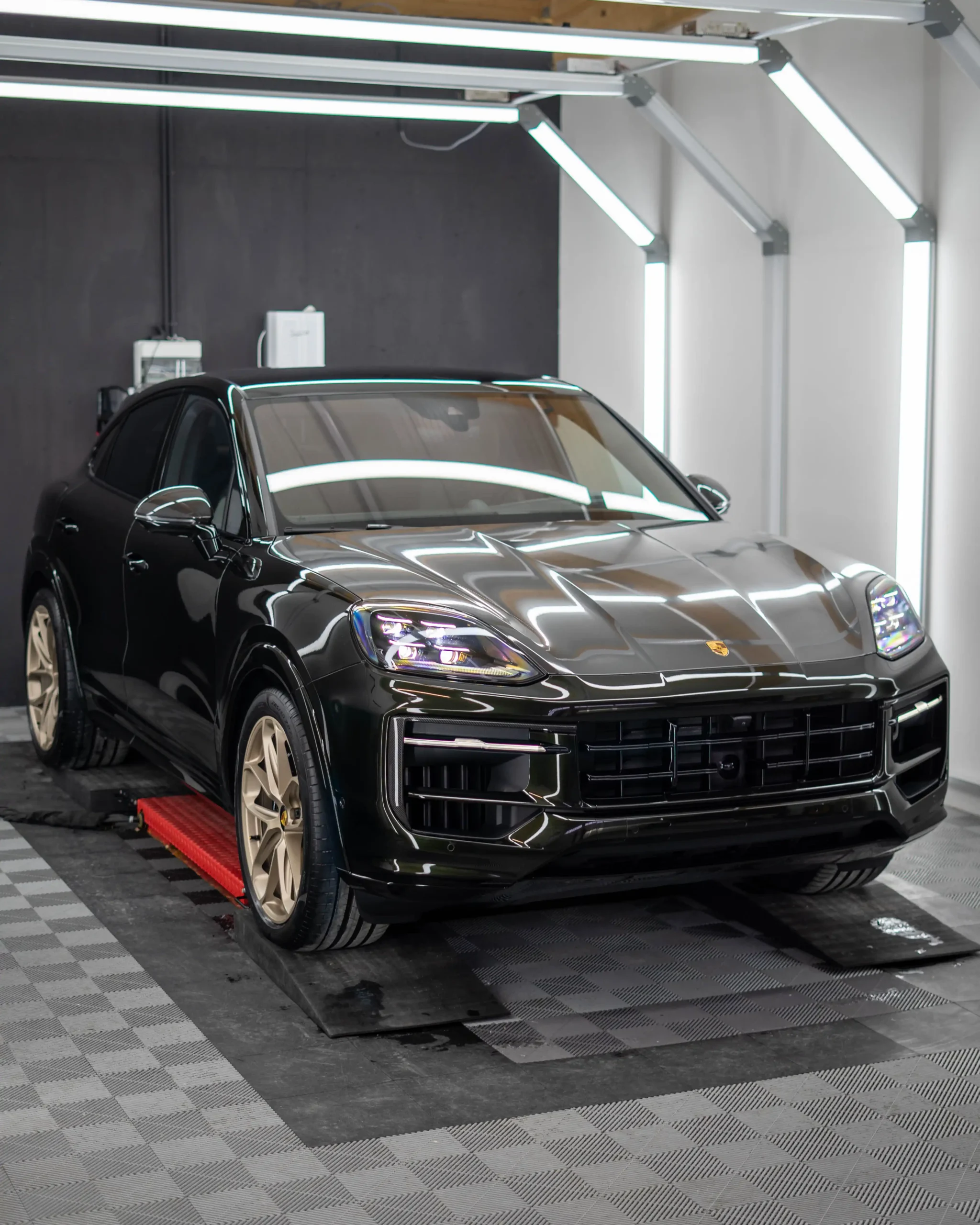 Ein frisch ausgelieferter Porsche Cayenne E-Hybrid in Dunkelolivmetallic des Modelljahres 2024.