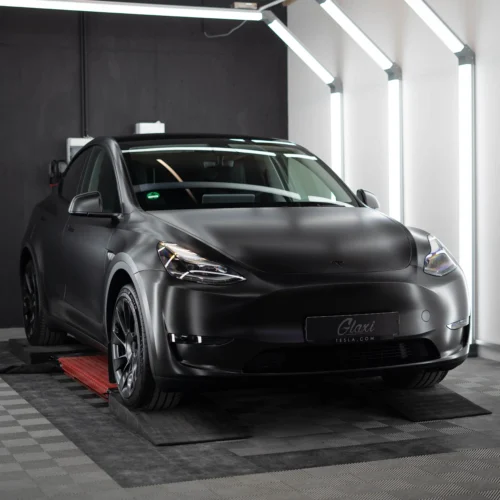 Ein Tesla Model Y foliert in Satin Schwarz das nun den "Stealth-Mode" aktiviert hat.