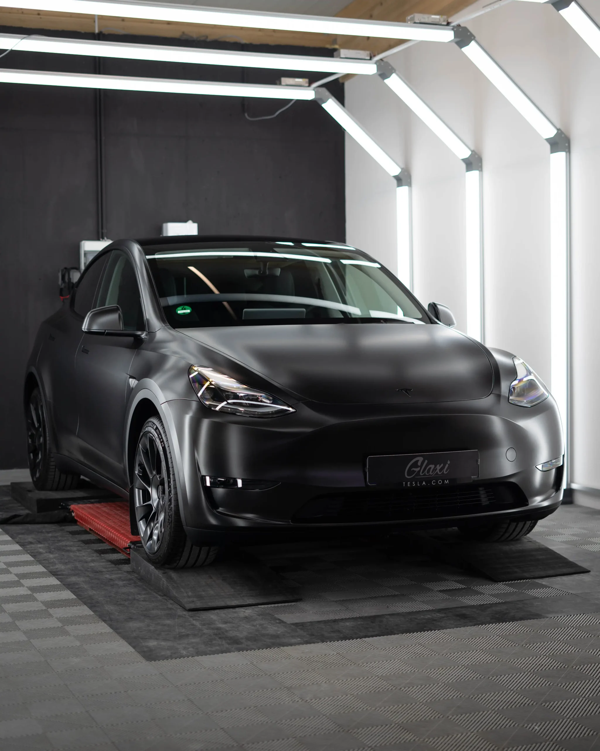 Ein Tesla Model Y foliert in Satin Schwarz das nun den "Stealth-Mode" aktiviert hat.